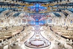 an elaborately decorated dining room with chandeliers and lights on the ceiling is seen in this image