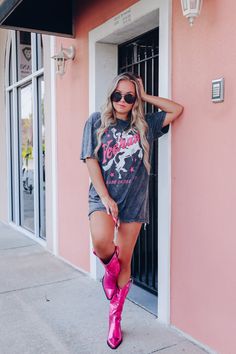 You can't go wrong with a graphic tee. They're so versatile and perfect for more than just casual wear. Do a bra tuck with shorts and sneakers, or size up and style with biker shorts and slides for a sporty vibe!! Features a super soft cotton fabric, crew neck, boyfriend fit (loose in all the right places), mineral wash black base, with hand drawn graphics of a cowboy on a horse holding his hat up, hot pink stars, and "Yeehaw, Made In The West". Fit: Relaxed fit, model is wearing a large. Approx Hot Pink Nashville Outfit, Nashville Pink Outfits, Graphic Tee Concert Outfit, Country Casual Outfits, Pink Tshirt Outfit, Nashville Vibes, Salon Outfits, Pink Concert Outfit, Cowboy On A Horse