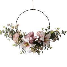 a wreath with flowers and greenery hanging from it