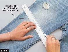 a woman measuring her jeans with a tape and measure ruler on the bottom of it