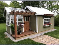 a small shed with a white roof and windows