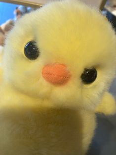 a small yellow stuffed animal sitting on top of a table