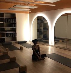 a woman sitting on the floor in a yoga studio