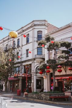 an old building with lanterns hanging from it's roof and trees in front of it