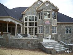 a stone house with steps leading up to the front door and windows on each side