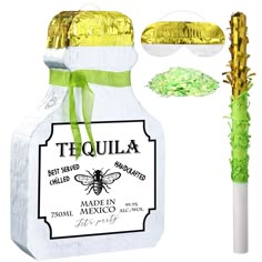 a bottle filled with green and gold confetti next to a paper bag that says tequila