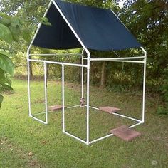 a white structure with a blue roof in the grass