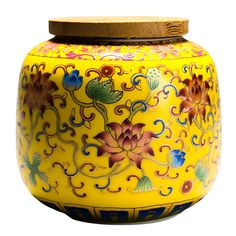 a yellow vase with flowers painted on it and a wooden lid in the shape of a flower