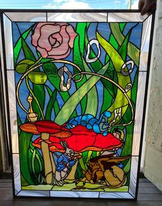 a stained glass window with flowers and plants