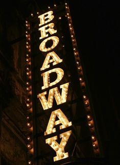 the broadway sign is lit up at night