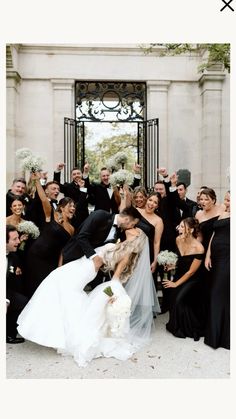 a bride and groom kissing in front of their wedding party