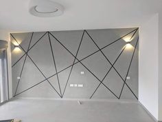 an empty room with white walls and black lines painted on the wall, along with lights