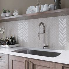 a kitchen sink with a faucet and some dishes on the shelf above it