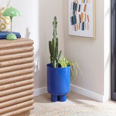 a blue planter sitting on top of a wooden table next to a door way