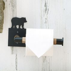 a towel holder with a bear on it and a white napkin hanging from the wall