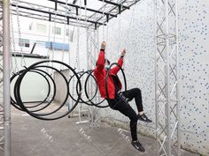 a man is hanging upside down on some kind of metal structure with his hands in the air