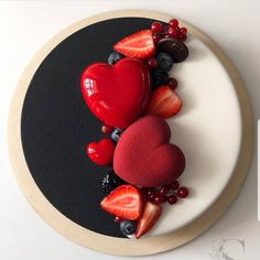 a plate topped with strawberries, berries and heart shapes