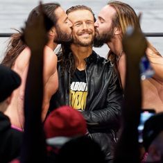 two men kissing each other in front of a crowd