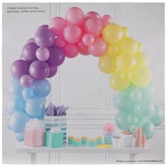 there is a table with balloons and gifts under the rainbow colored arch that reads, create balloon art for your child's birthday