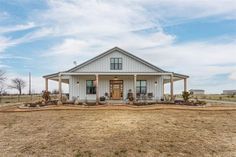 a white house sitting on top of a dry grass field