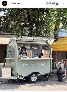 a mobile food cart parked in front of a building with an awning over it