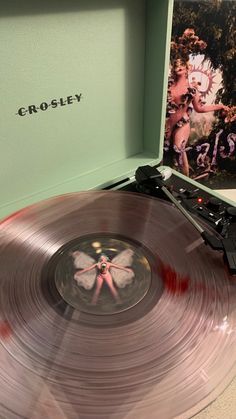 an old record player sitting on top of a table next to a vinyl album cover