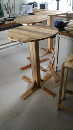 a table made out of wooden planks in a room with other tables and stools