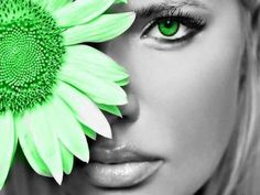 a woman with green eyes holding a flower