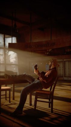 a man sitting in a chair with his feet up on a table while reading a book