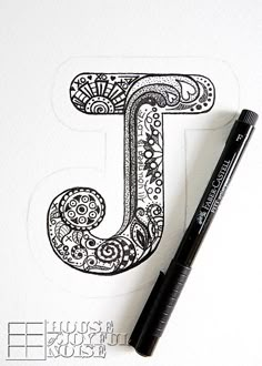 the letter j is made up of intricately designed letters and numbers, along with a black marker