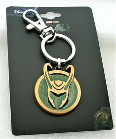 a metal keychain with a green and gold design on it's side