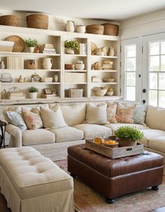 a living room filled with furniture and lots of shelves on the wall above it's windows