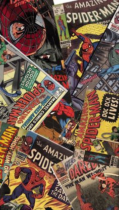 many different comics are stacked on top of each other in this pile, with one being the spider - man