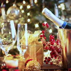 a table topped with wine glasses and christmas decorations