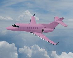 a pink plane flying through the sky with clouds in the backgrounnds