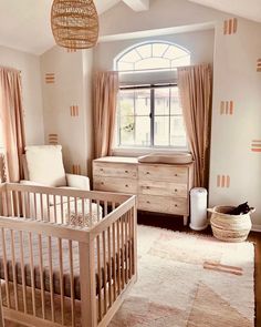 a baby's room with a crib, dresser and bed in it is shown