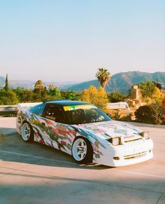 a white car with colorful graphics parked in a parking lot