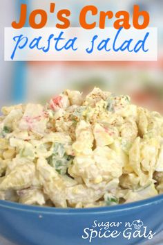 a blue bowl filled with pasta salad on top of a table next to a sign