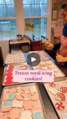 a woman standing in front of a counter filled with cookies