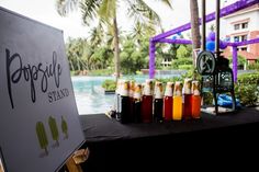 bottles of liquid are lined up on a table next to a sign that says popsicle island