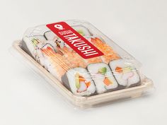 a plastic container filled with sushi on top of a white table