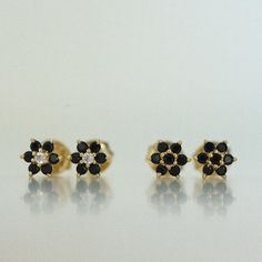 Dainty flower shaped stud earrings. Perfect for pairing with multiple piercings. Made of 925 Sterling Silver We use a THICK, DURABLE plating of 14K Gold, Rose Gold or Rhodium - for a piece that will last you years to come! Highest Grade CZ for an authentic diamond look! Nickel-free & Hypoallergenic Dimensions: 5.8mm Available in Emerald, Ruby, Sapphire, and White Cubic Zirconia Black Diamond Earrings For Gift, Black Flower Shaped Earrings For Gift, Black Flower Earrings As Gift, Black Flower-shaped Earrings For Gift, Black Flower Drop Earrings For Gift, Stud Earrings Black, Black Studs, Huggie Earrings Gold, Small Stud Earrings