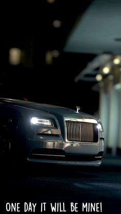 a black rolls royce parked in a parking lot at night