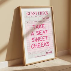 a sign that says guest check on it in front of a wall with the words take a seat, sweet cheeks