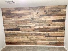 an empty room with wood planks on the wall and carpeted floor in front of it