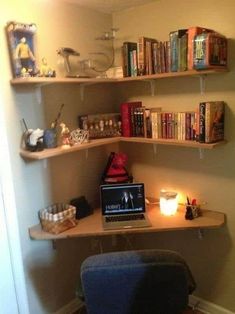 a laptop computer sitting on top of a wooden desk next to a book shelf filled with books