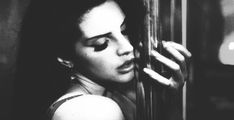 a black and white photo of a woman with her eyes closed, leaning against a wall