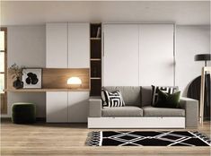 a living room filled with furniture and lots of white cupboards next to a window