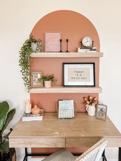 a wooden desk topped with shelves filled with books and plants next to a wall mounted clock