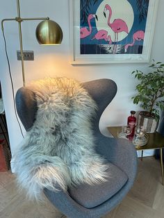 a grey chair with a furry pillow on top of it